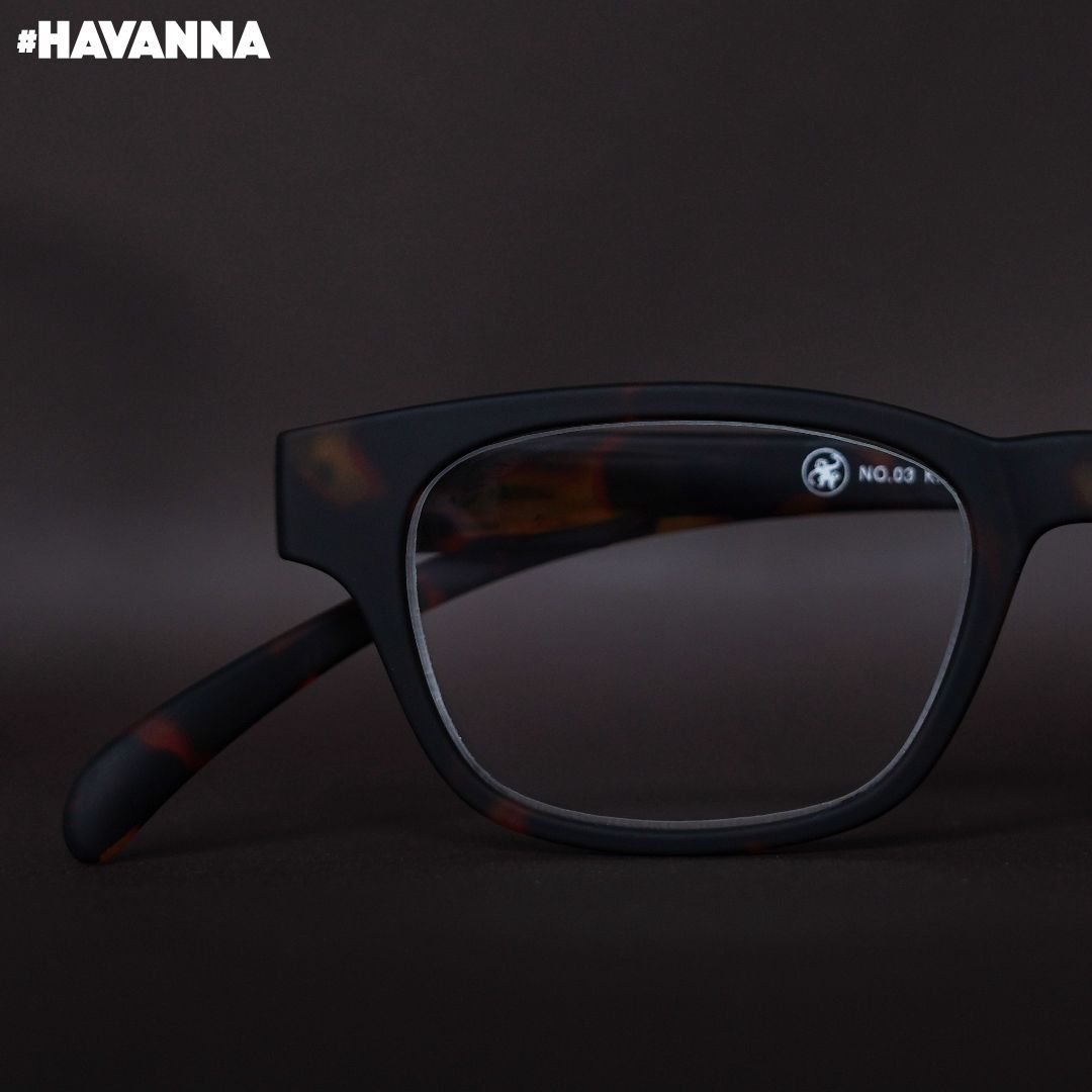 Eine havanna farbene Lesebrille auf braunem Hintergrund.