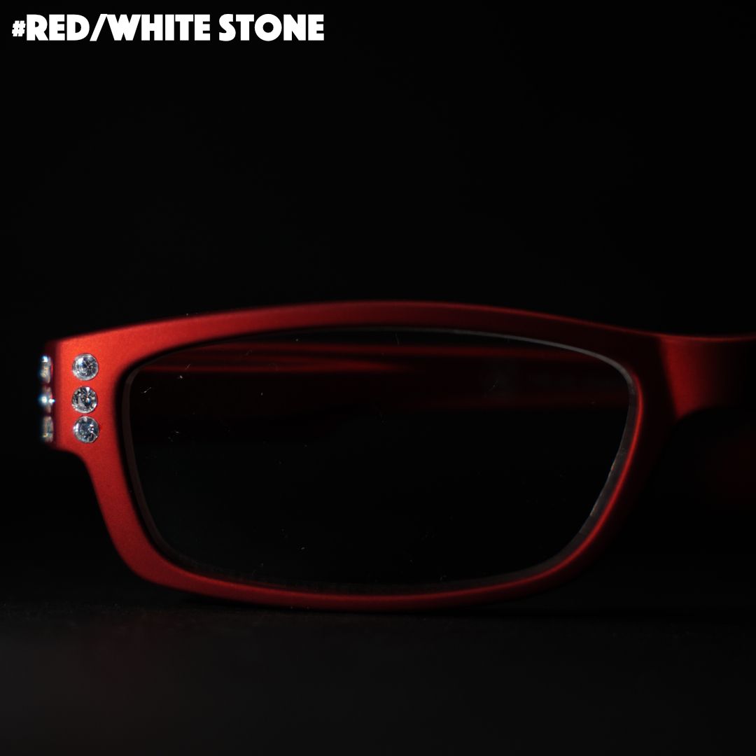 Eine rote Lesebrille mit Strasssteinen auf schwarzem Hintergrund.