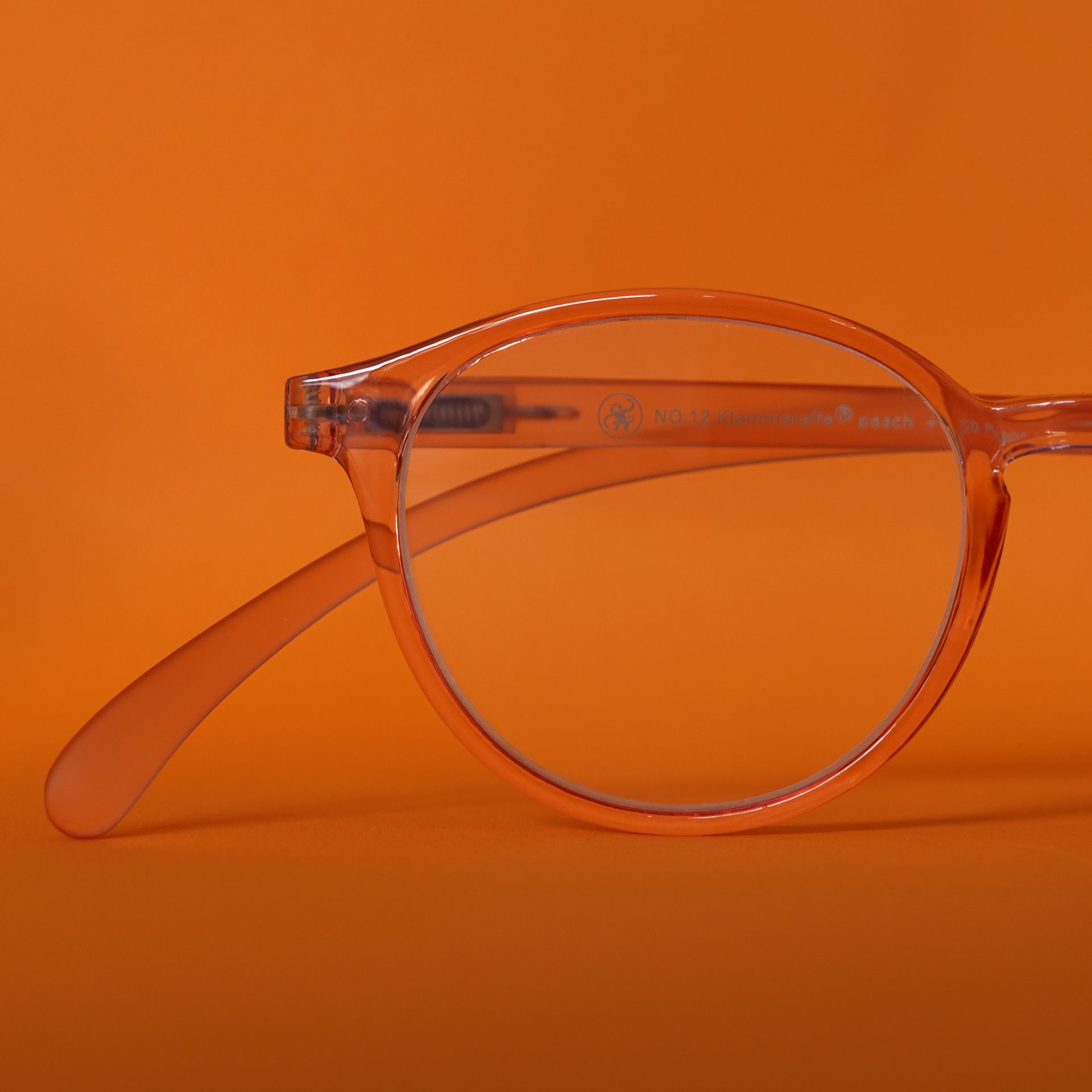 Orange getönte Brille auf orangefarbenem Hintergrund.