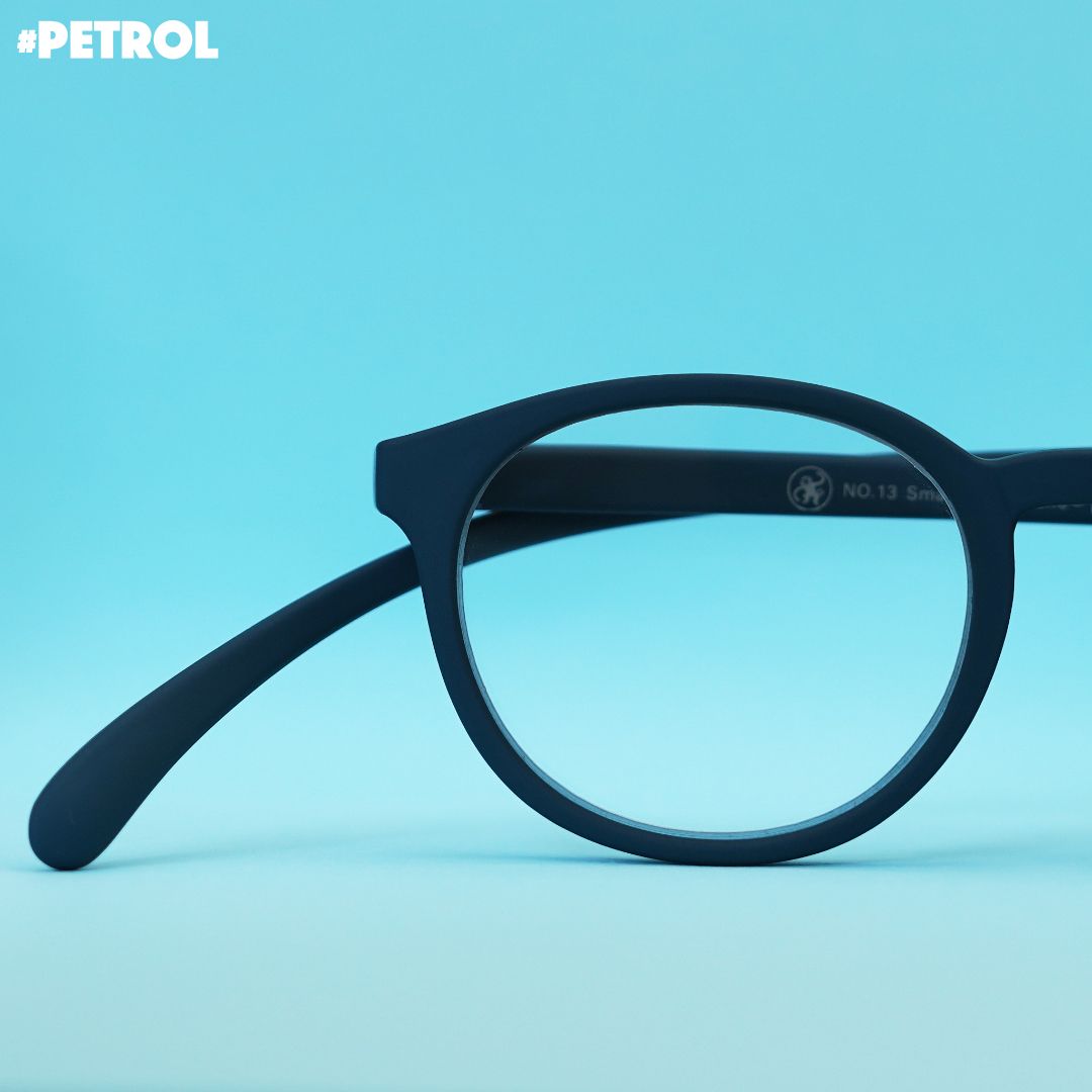 Eine petrol farbene Panto-Brille auf blauem Hintergrund.