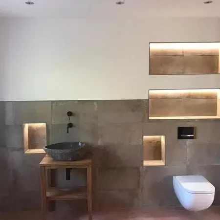 Ein Badezimmer mit Waschbecken, Toilette und Regalen.