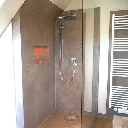 Ein Badezimmer mit ebenerdiger Dusche und Handtuchhalter.