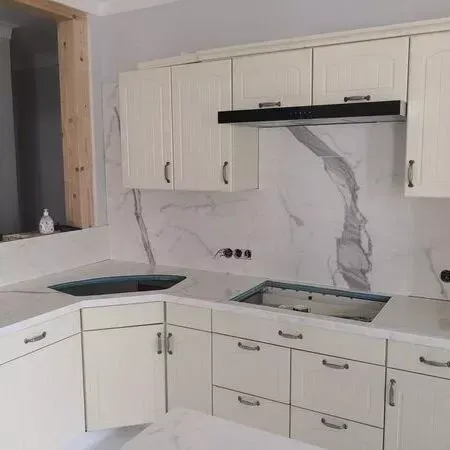 Eine Küche mit weißen Schränken und Marmorarbeitsplatten.