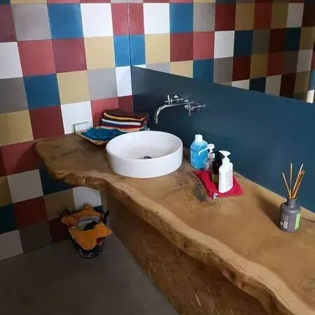 Ein Badezimmer mit einer Holzablage und einem Waschbecken