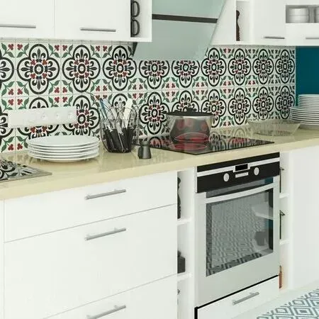 Eine Küche mit weißen Schränken, einem Herd und einer gefliesten Wand.