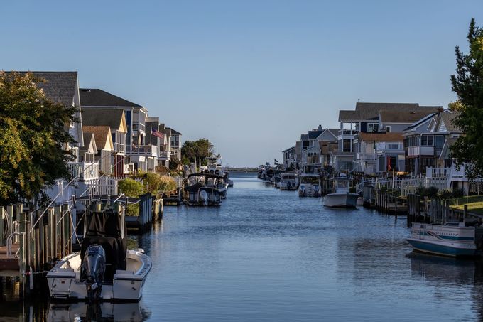 A row of houses along a river with boats in the water.