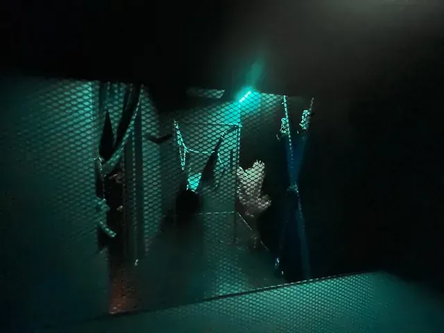Una persona está parada frente a un espejo en una habitación oscura.