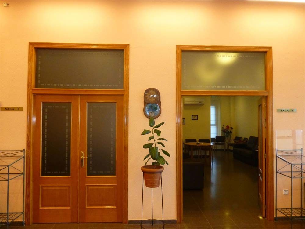 Una planta en una maceta se encuentra entre dos puertas en una habitación.