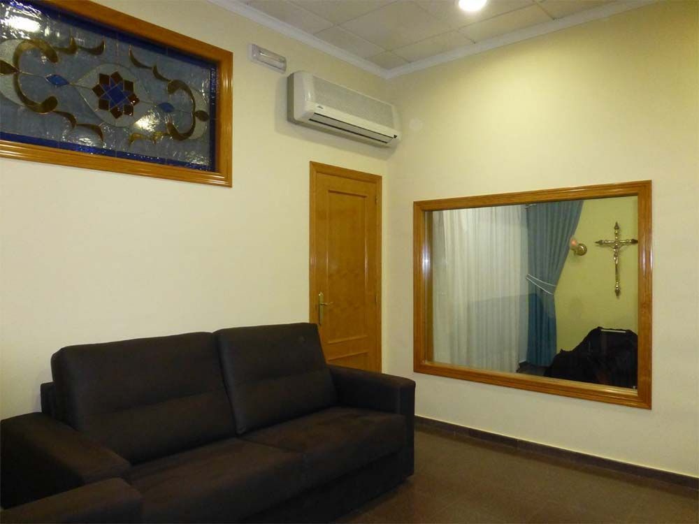 Una sala de estar con un sofá y un espejo grande.