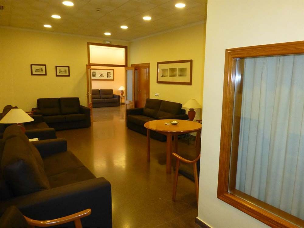 Una sala de estar con un sofá, una mesa y una ventana.