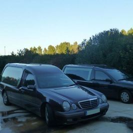 Dos coches negros están aparcados uno al lado del otro en un estacionamiento.