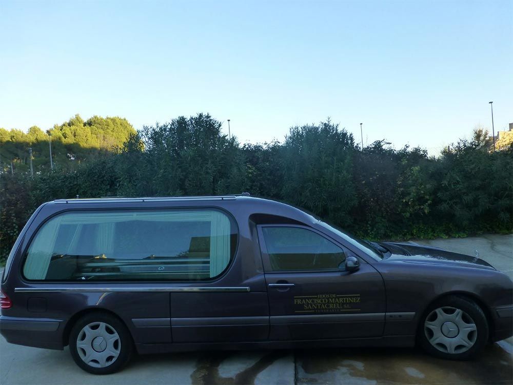 Un coche fúnebre morado está estacionado en un estacionamiento.