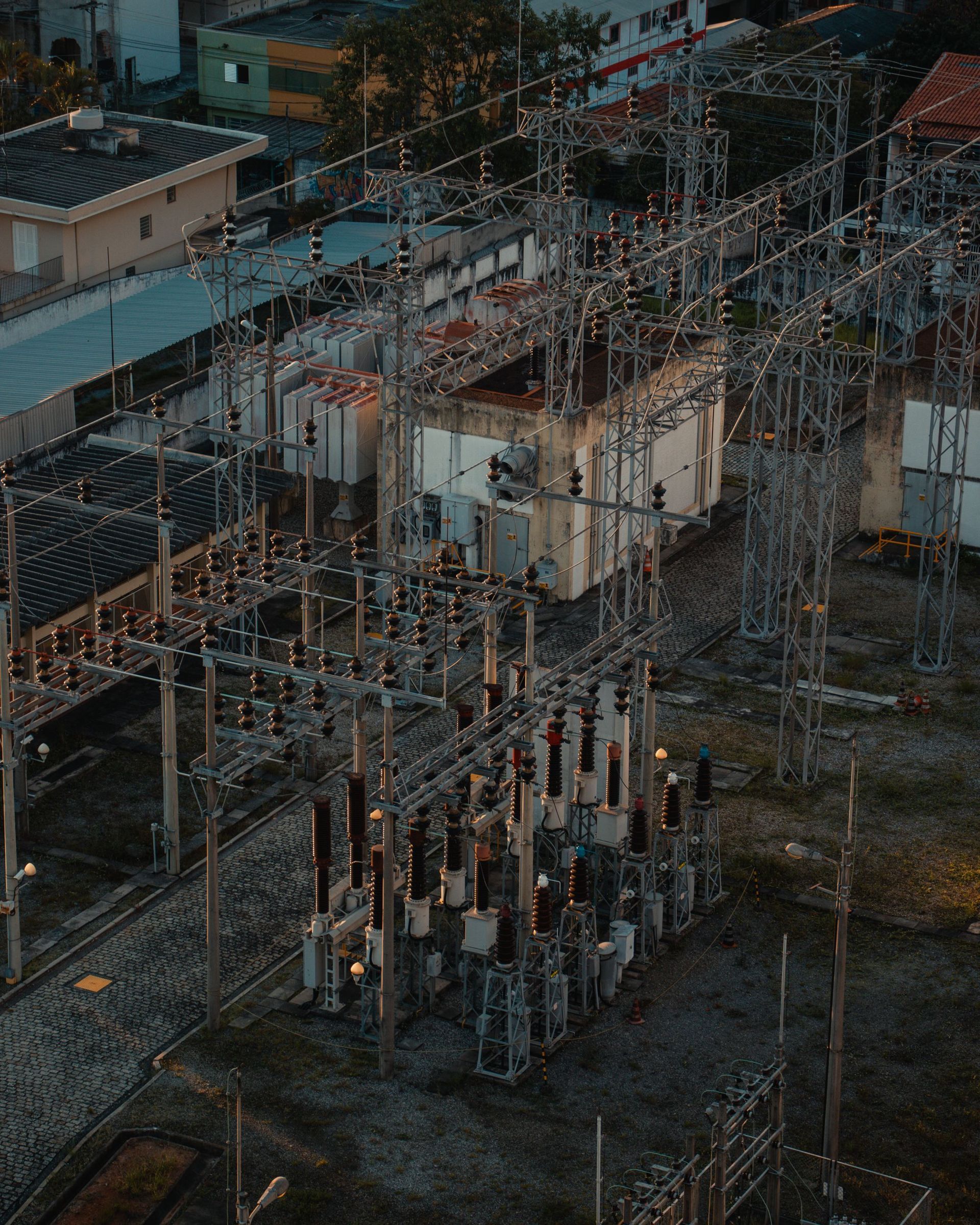 Poste de transformation électrique avec pylônes métalliques, transformateurs et lignes électriques au crépuscule