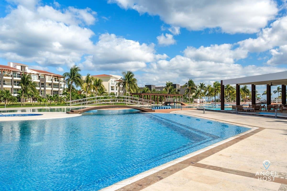 There is a large swimming pool in the middle of a resort.