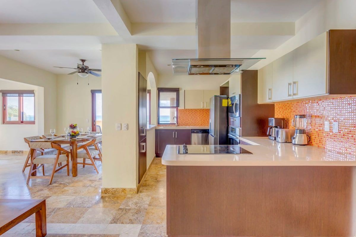 A kitchen with a refrigerator , stove , sink , and a table.