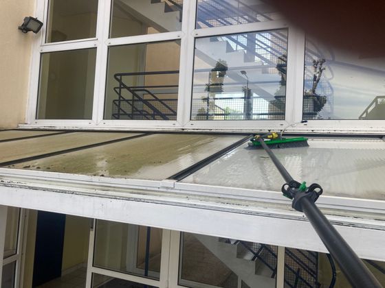 Perches de nettoyage de vitres permettant d’atteindre les fenêtres du deuxième étage d’un bâtiment, depuis l’extérieur