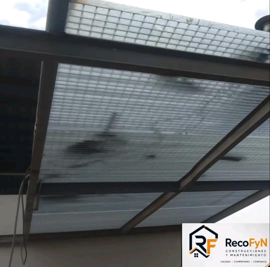 Panel de techo translúcido con estructura metálica, con una mancha oscura o algún daño, visto desde abajo.