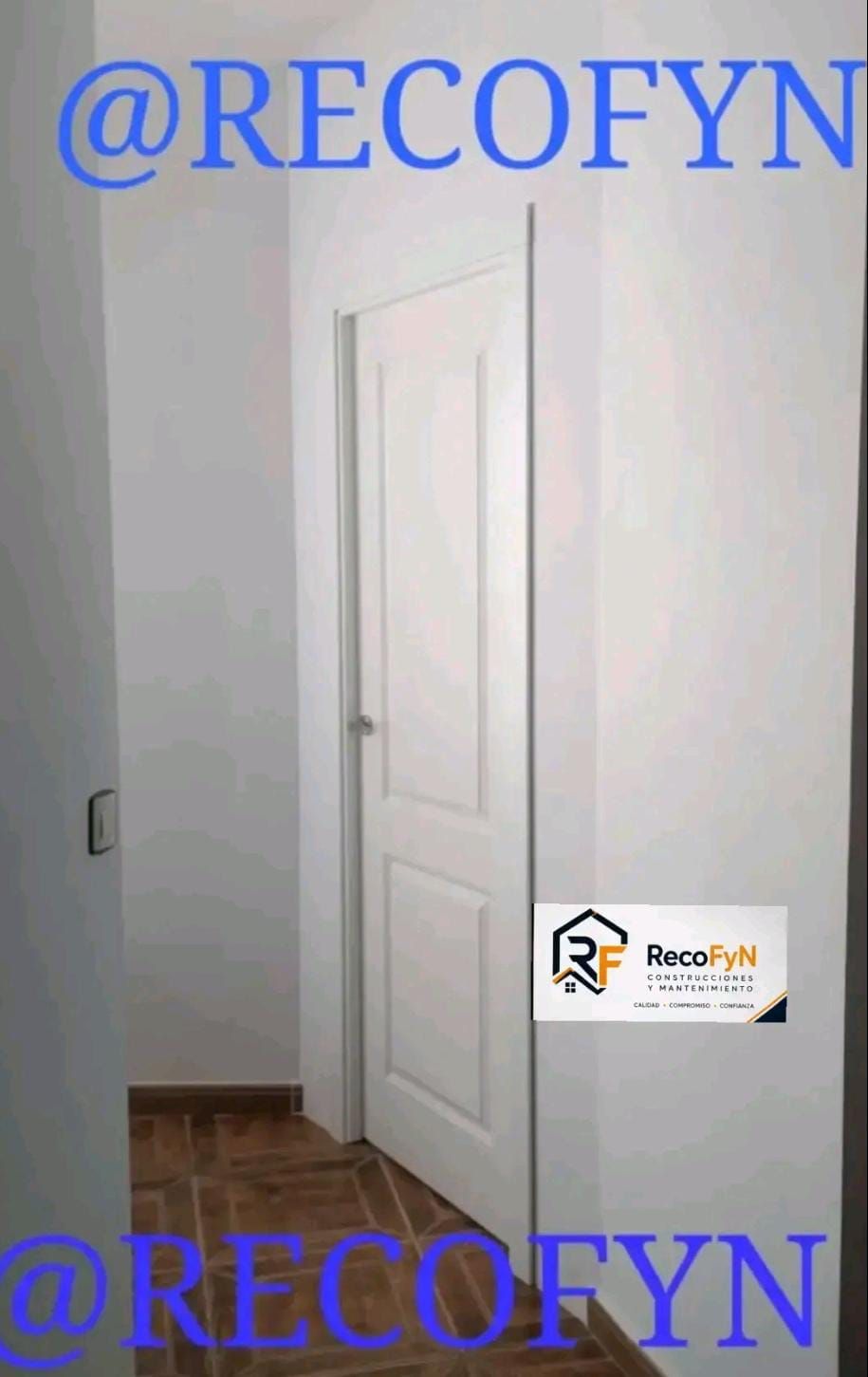 Puerta interior blanca en una habitación sencilla con suelo de madera y una pegatina con el logotipo en la pared.