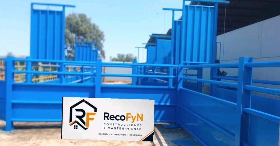 Equipo industrial de metal azul con barandillas y contenedores, de la marca RecoFyN, al aire libre en un día soleado.