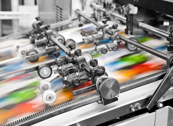 Una máquina de impresión está imprimiendo muchos papeles coloridos.