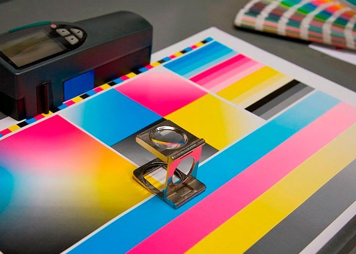 Una lupa está colocada encima de un trozo de papel rayado de colores.