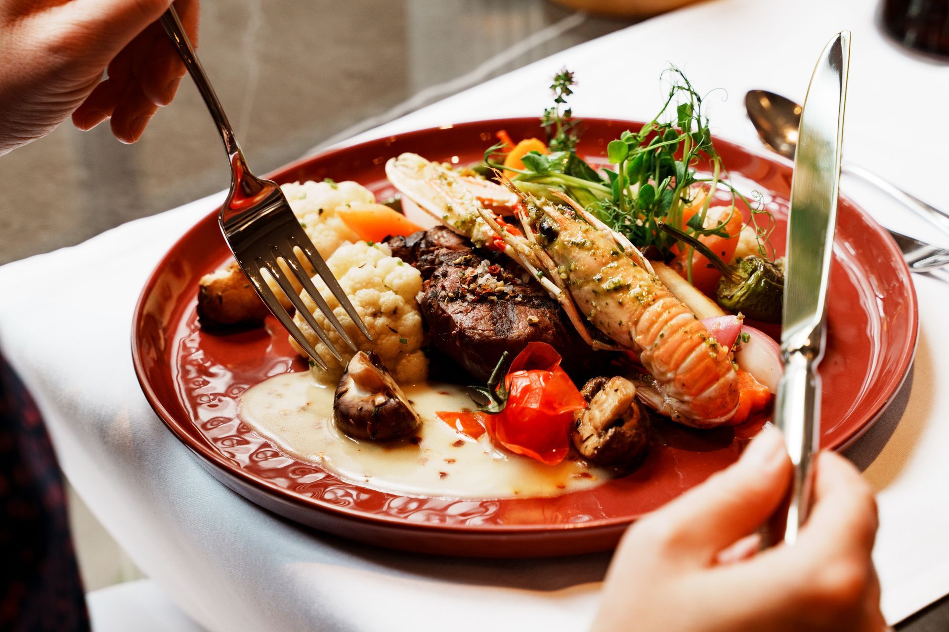 Ein Teller mit Languste und verschiedenen Beilagen.