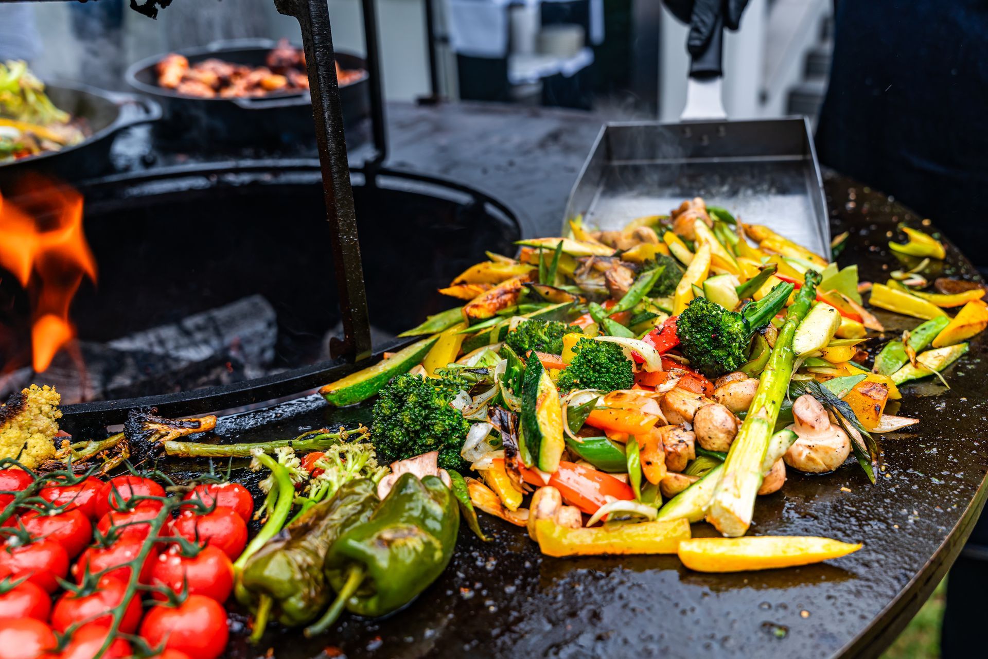 Eine Person grillt Gemüse.
