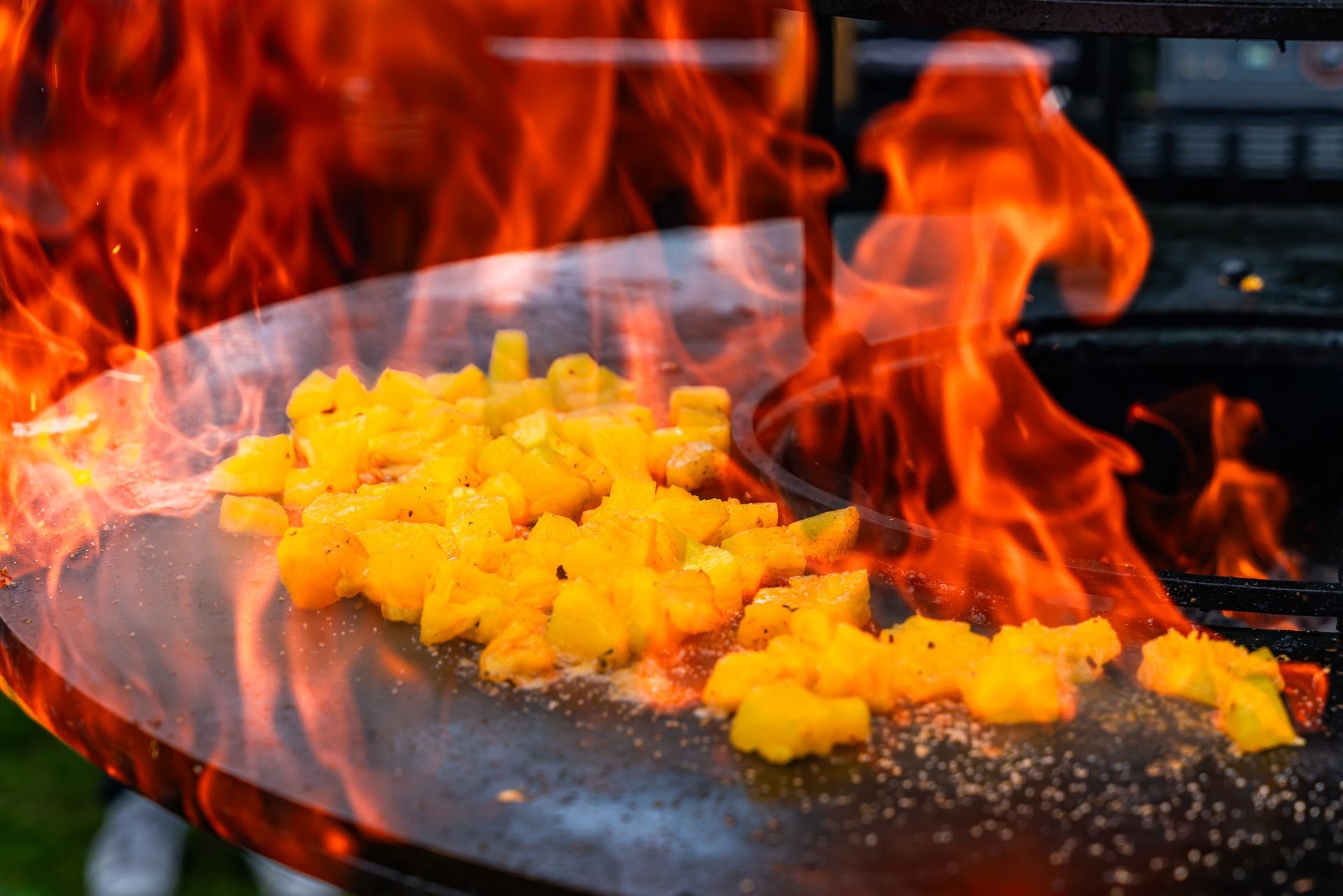 Auf einem Grill wird ein Teller mit Essen zubereitet, aus dem Flammen schlagen.