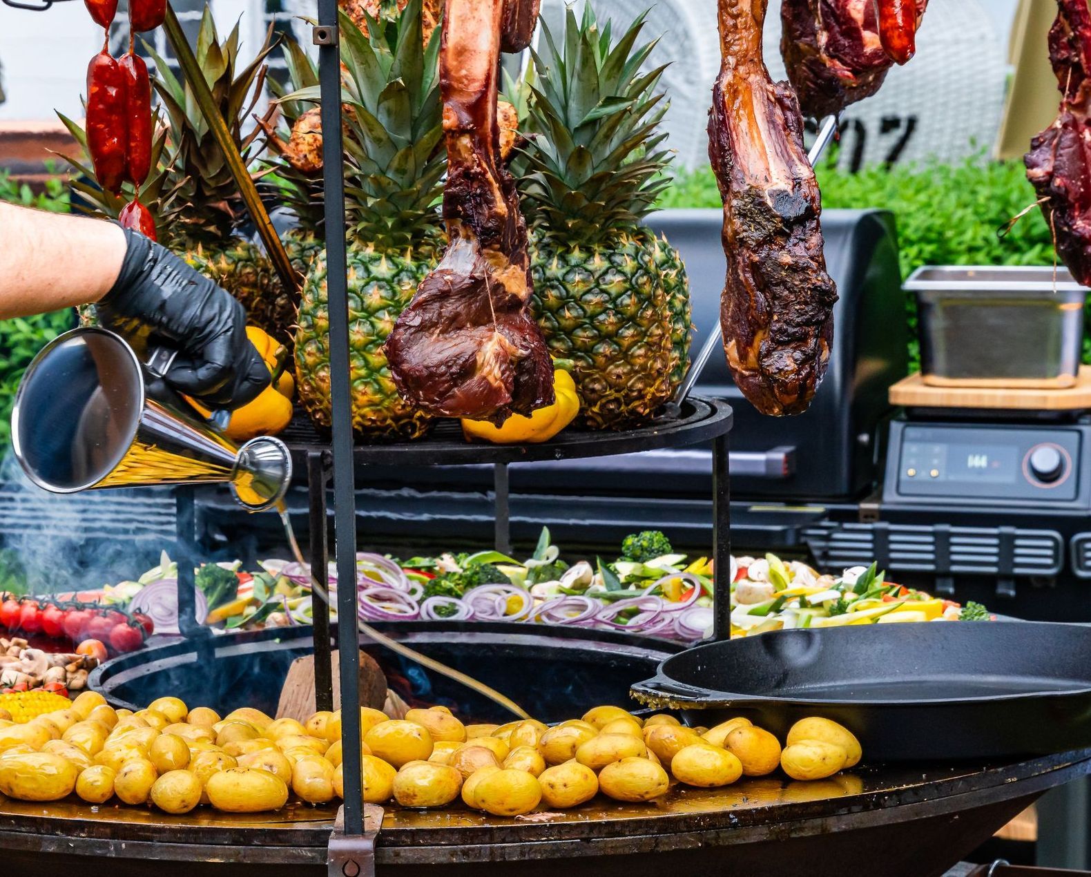 Eine Person grillt Kartoffeln und Fleisch.