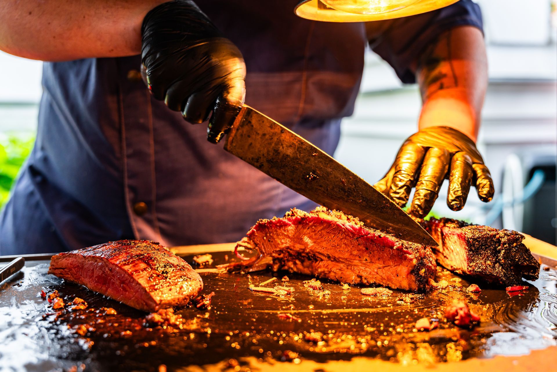 Eine Person schneidet ein Stück Fleisch auf einem Schneidebrett.