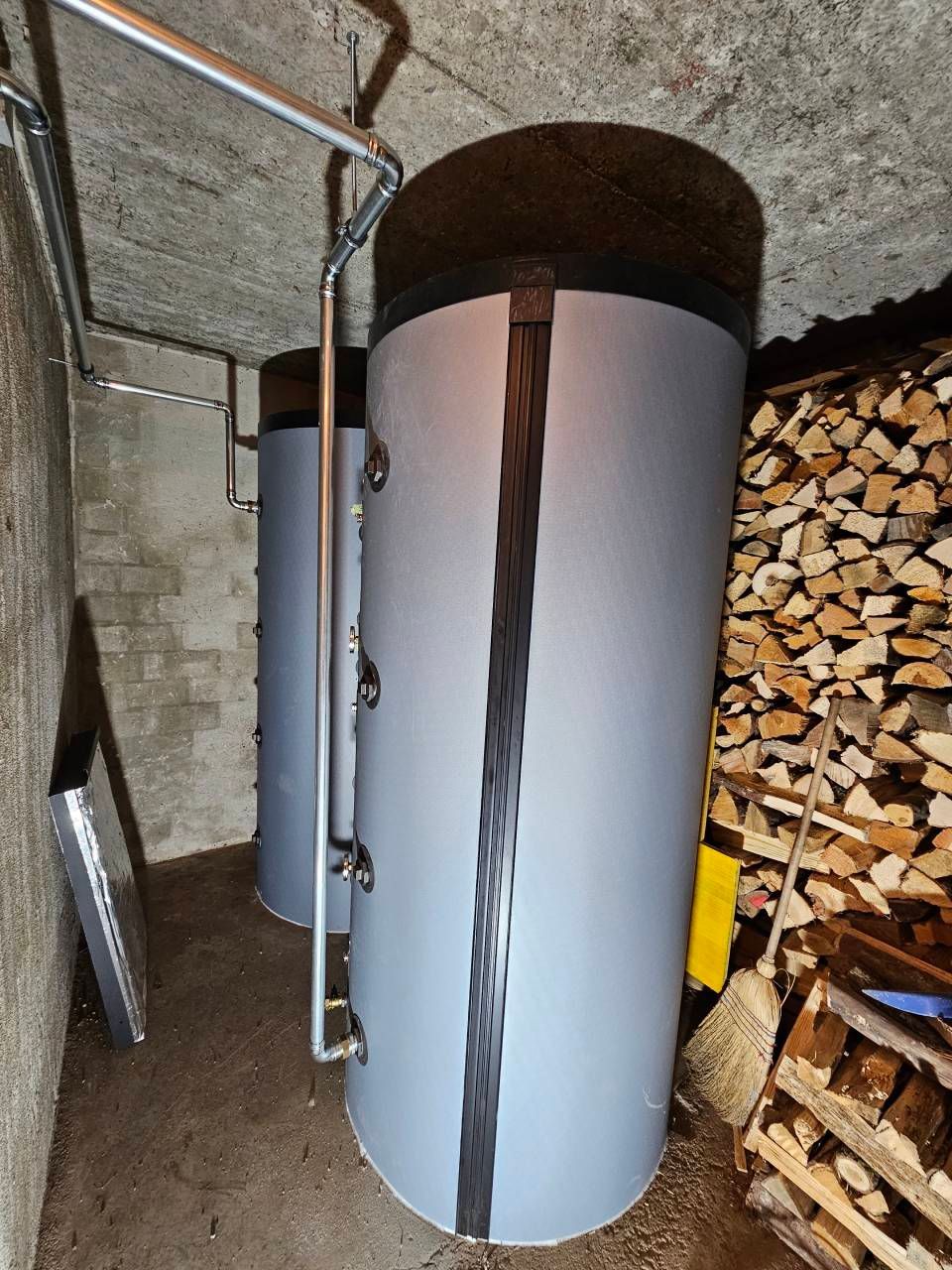 Ein weisser, vertikaler Heizkörper in einer gefliesten Ecke neben einem Mosaikboden.