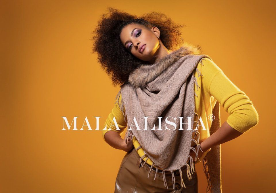 Eine Frau trägt einen Schal und einen gelben Pullover. Foto von Mala Alisha