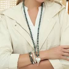 Eine Frau trägt eine Halskette und Armbänder an ihrem Handgelenk.