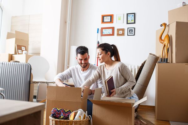 Un couple qui sort des objets de cartons de déménagement dans leur nouvelle maison