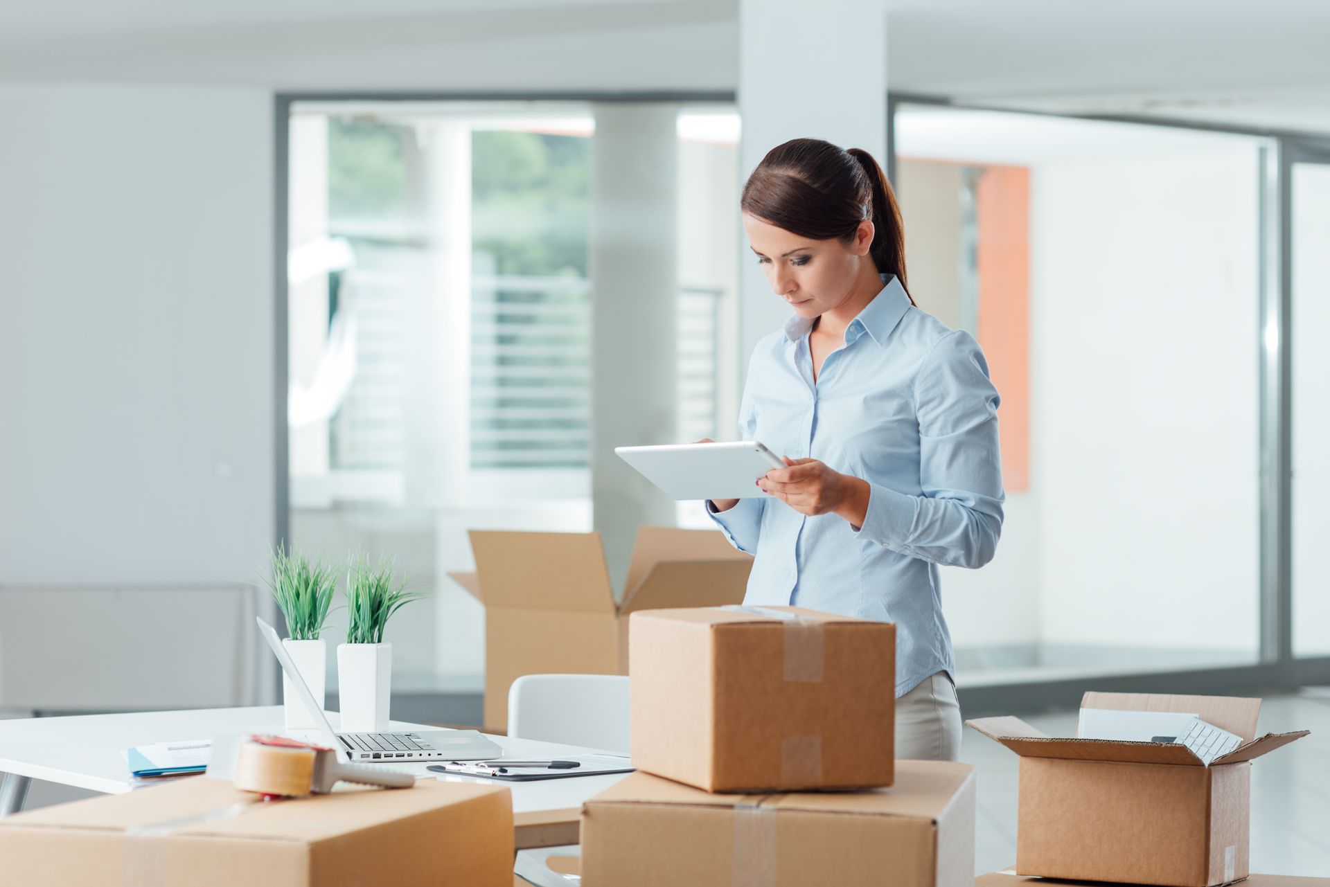 Une femme dans un bureau prépare des cartons pour un déménagement