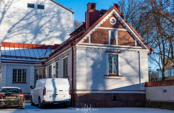 Luminen piha, jonka vieressä on valkoinen pakettiauto ja pieni valkoinen, punakattoinen talo