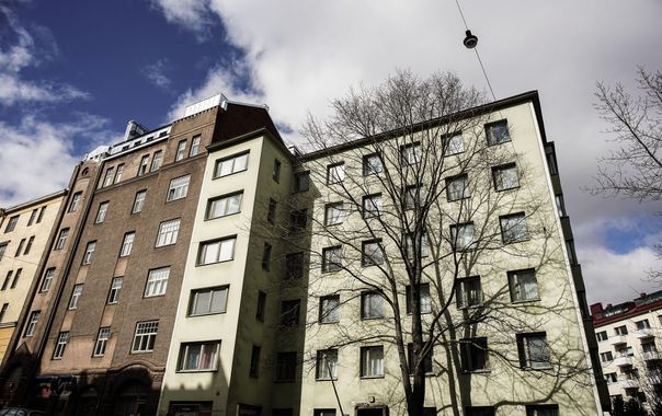 Korkeita kerrostaloja beigen ja ruskean julkisivuineen pilvisen sinisen taivaan alla