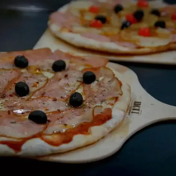 Una pizza sobre una paleta de madera que dice bkt