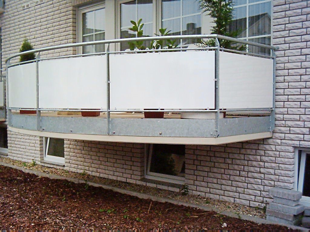 Ein weißer Balkon mit Metallgeländer an einem Backsteingebäude von Steffen Stahl GmbH & Co. KG