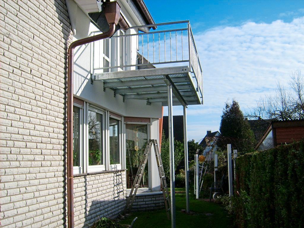 Ein weißes Backsteingebäude mit einem Balkon an der Seite Steffen Stahl GmbH & Co. KG