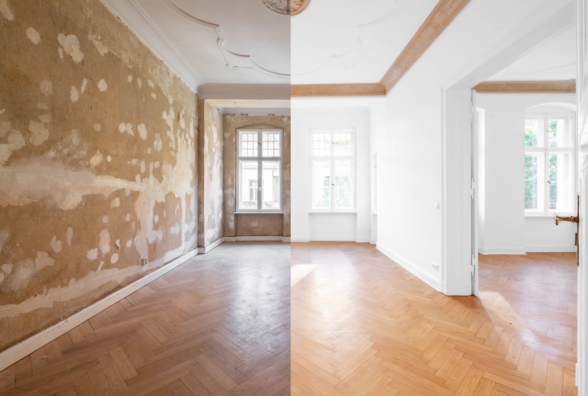Pièce vide avec un mur en plâtre usé, un parquet à chevrons et des fenêtres lumineuses au fond.