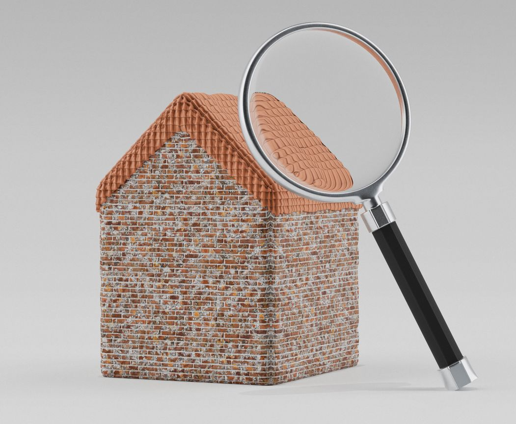 Maison en briques observée à la loupe, mettant en évidence le toit et les murs