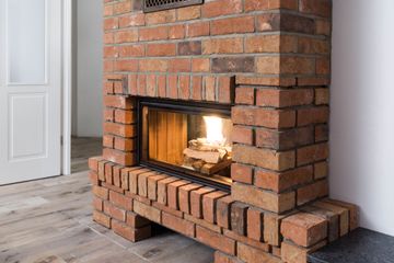 Cheminée en briques avec un feu qui brûle dans une pièce moderne