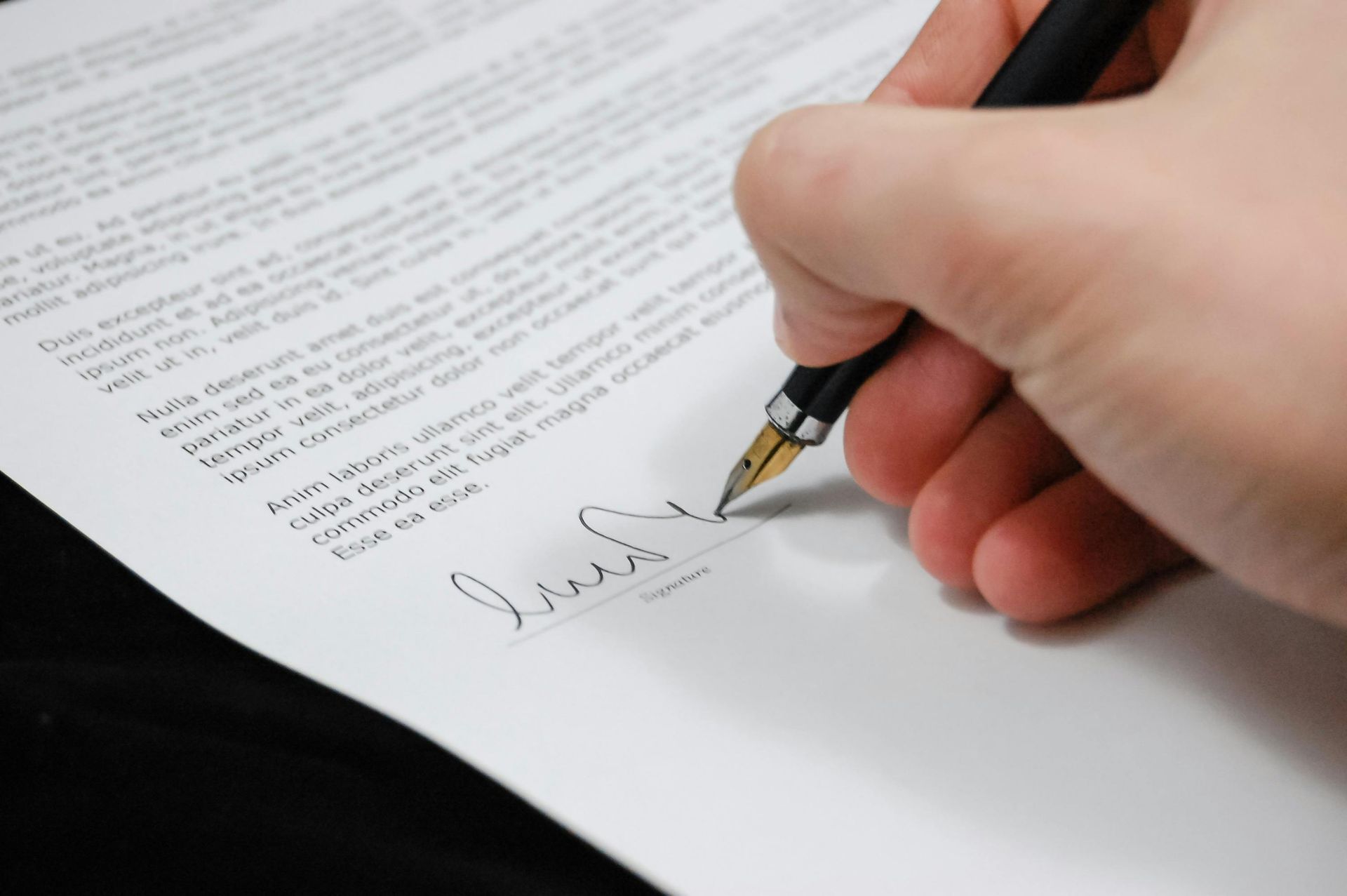 Una persona está firmando un trozo de papel con un bolígrafo.