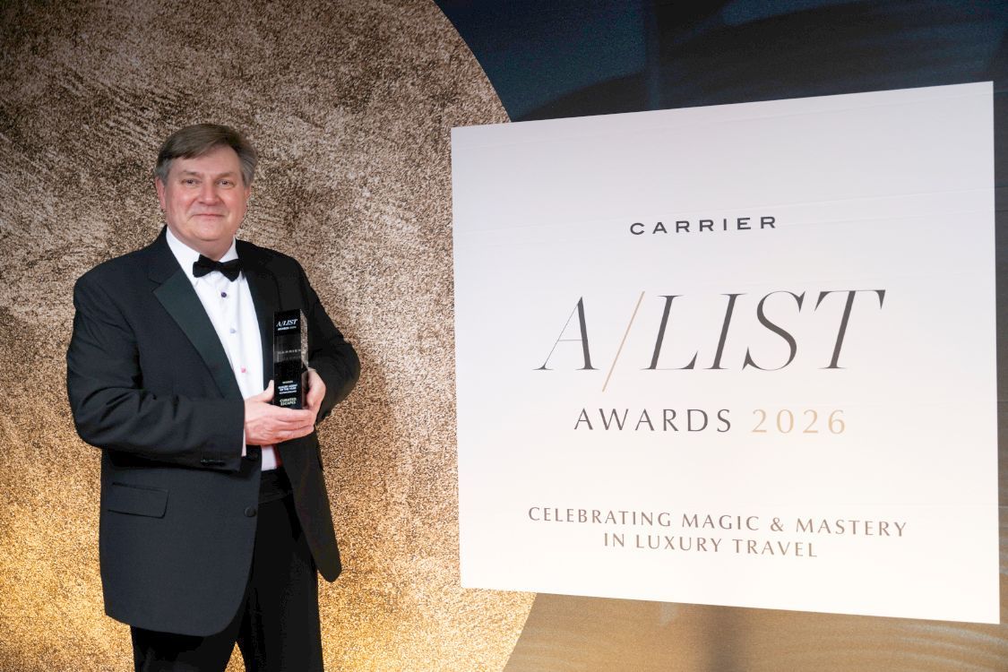 Man in tuxedo holding an award beside a sign reading “A List Awards 2026”