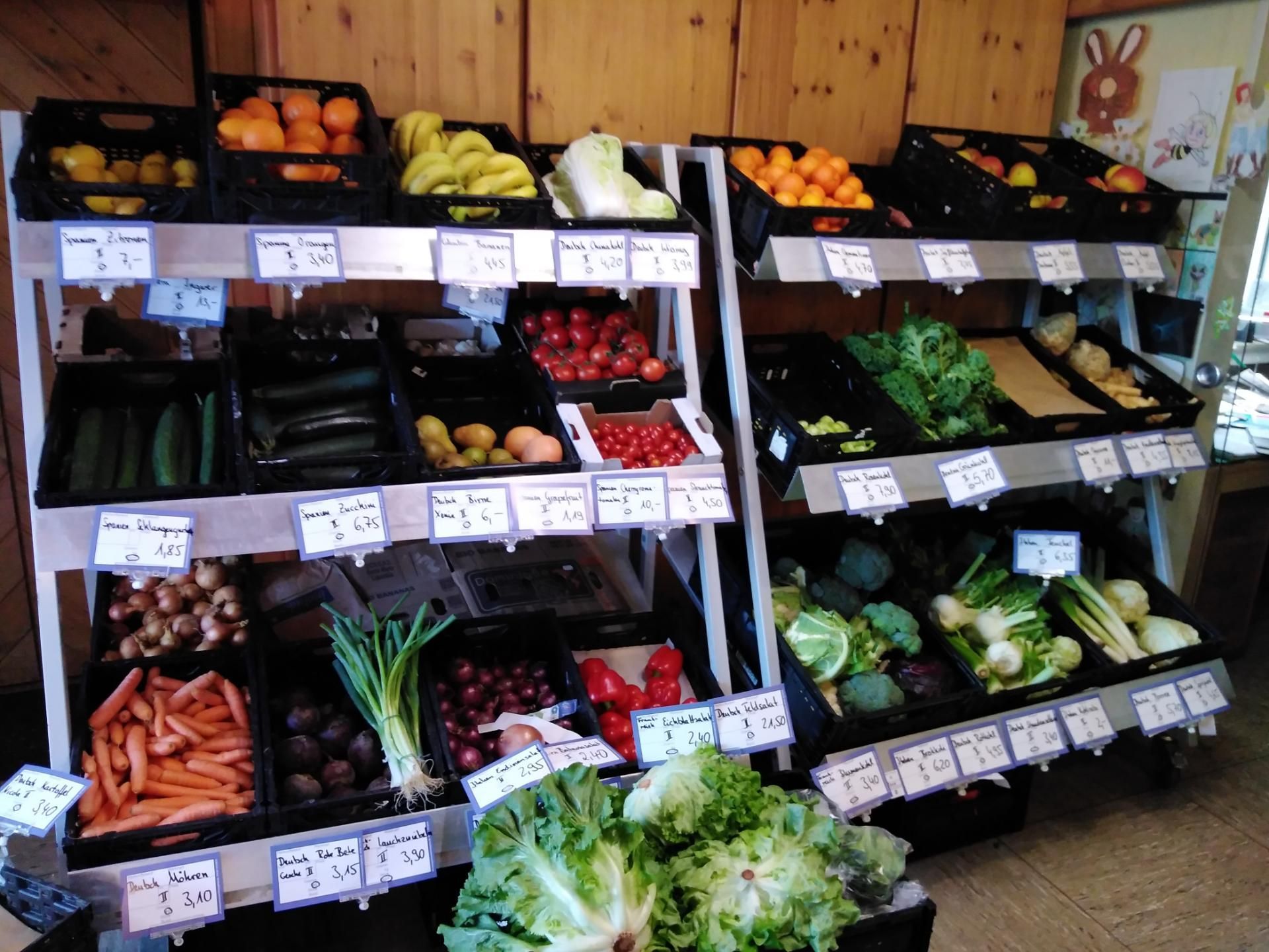 In einem Geschäft sind verschiedene Obst- und Gemüsesorten ausgestellt.