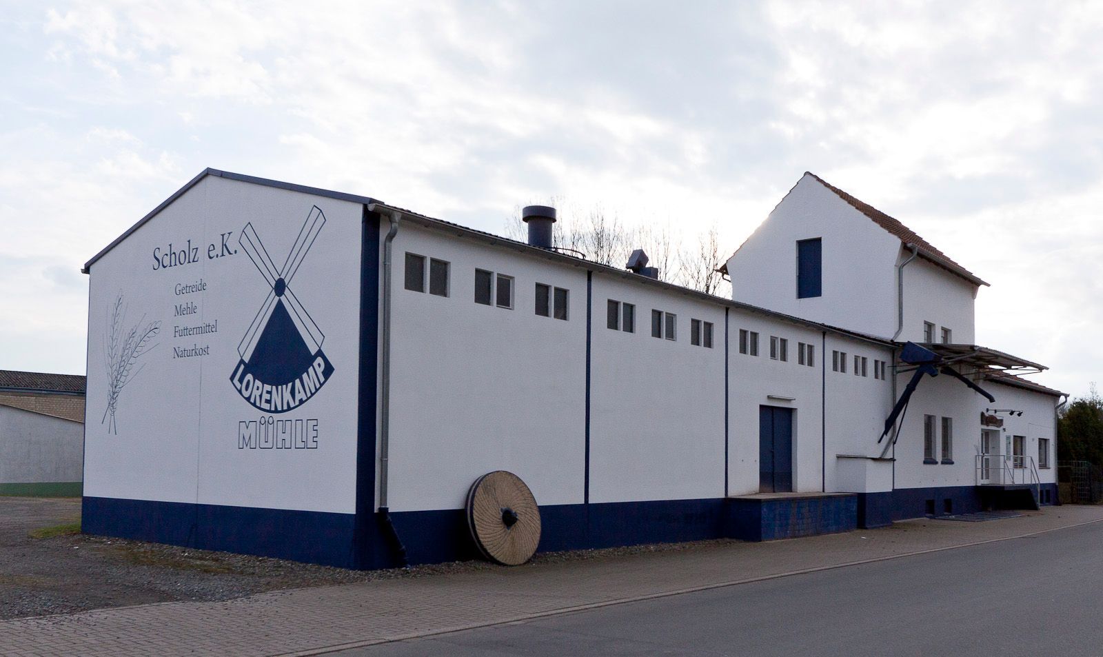 In einer Bäckerei hält eine Frau einen Laib Brot in einer Papiertüte.