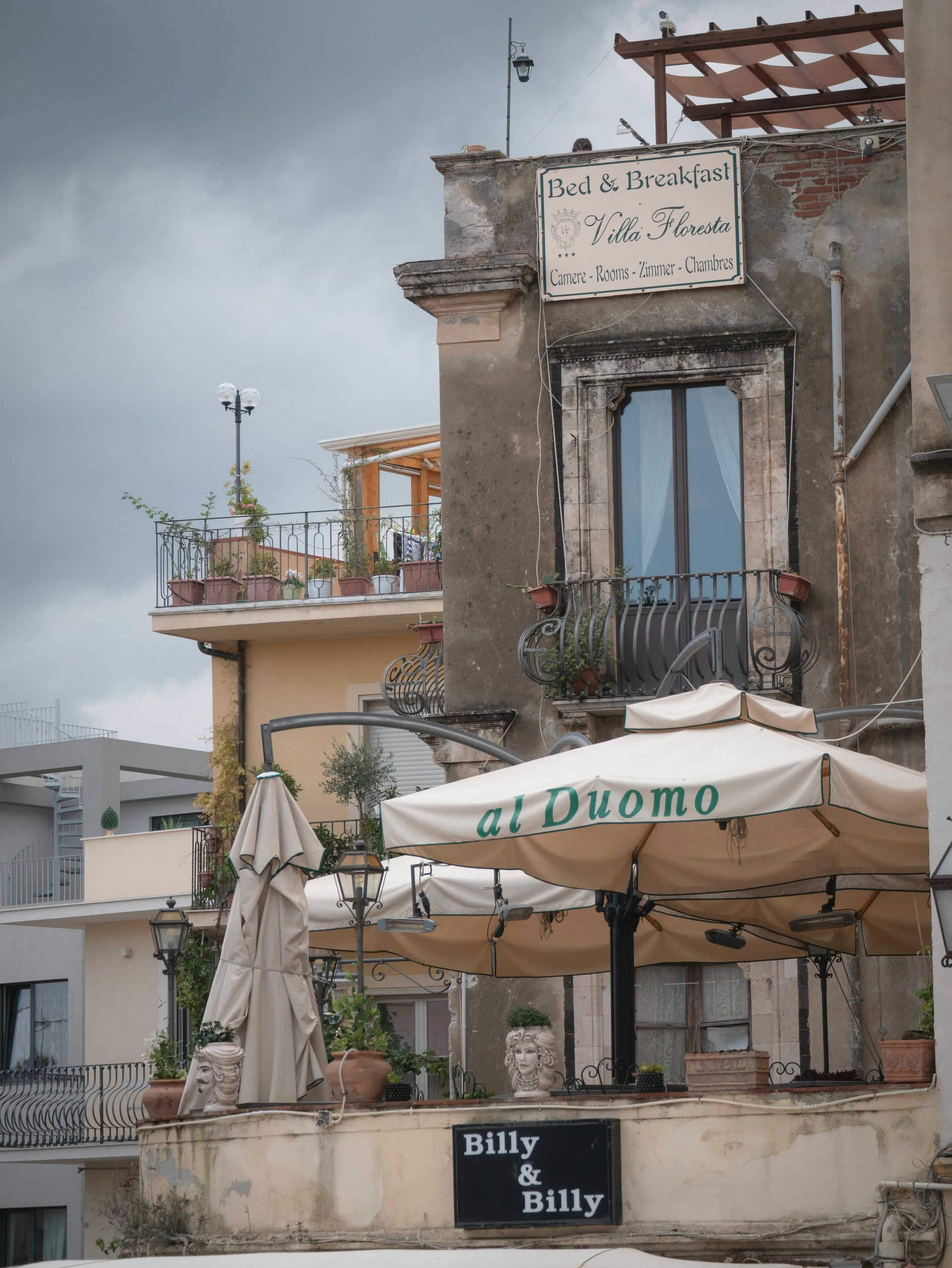 A building with umbrellas and a sign that says nutty & billy