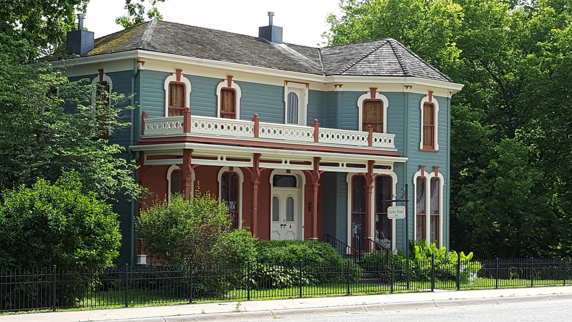 A large blue and red house with a fence around it