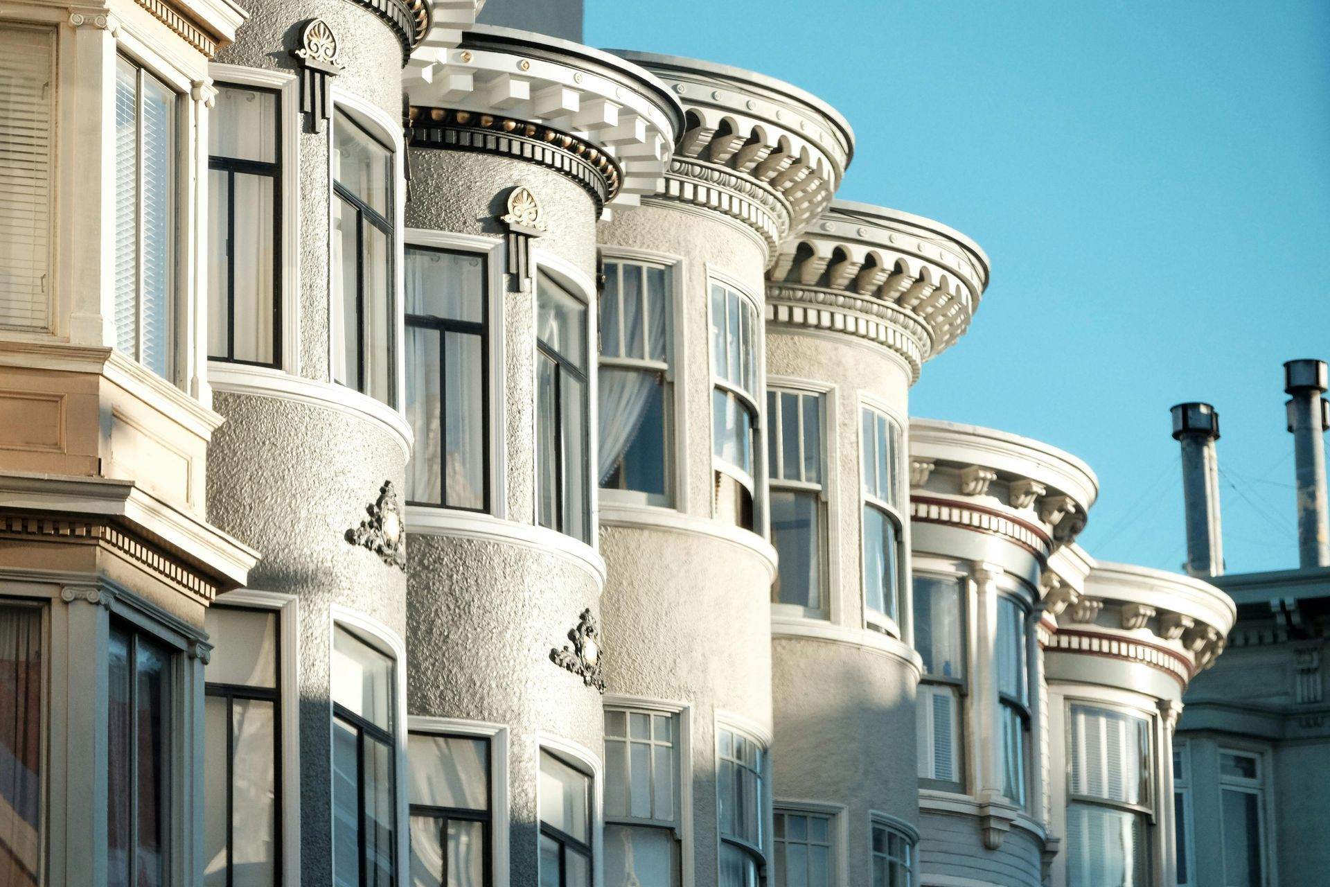 A row of houses with a blue sky in the background.